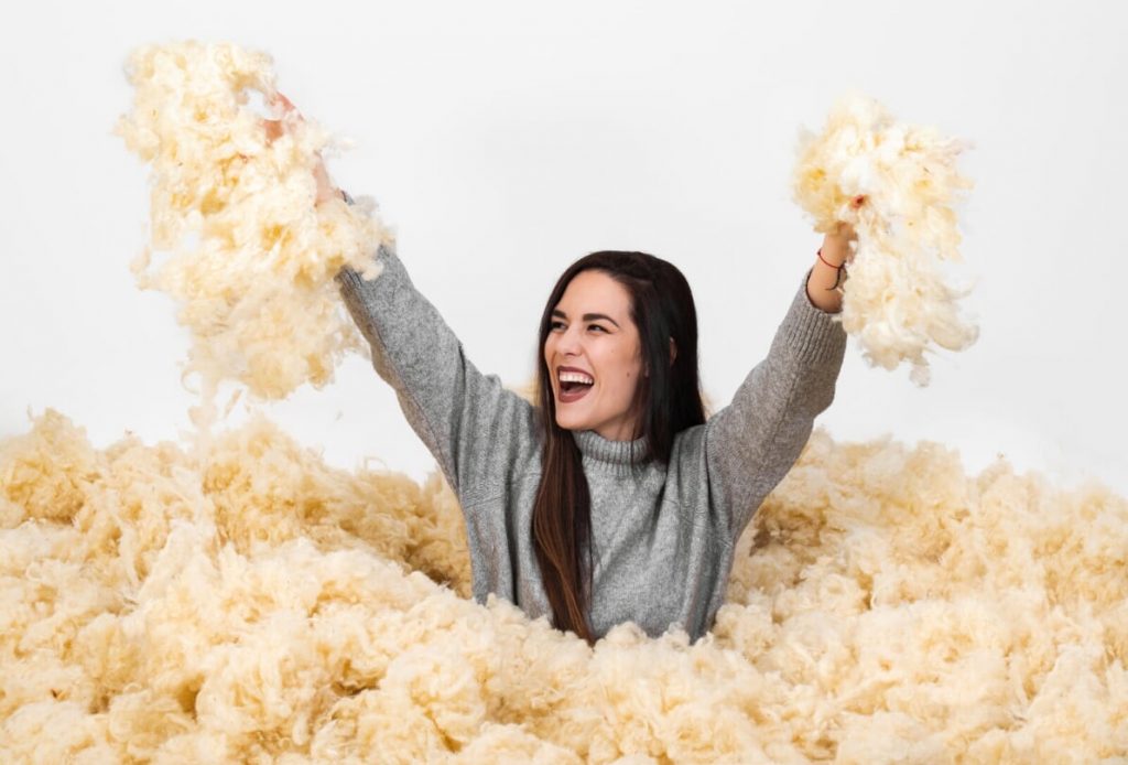 girl playing in wool pile