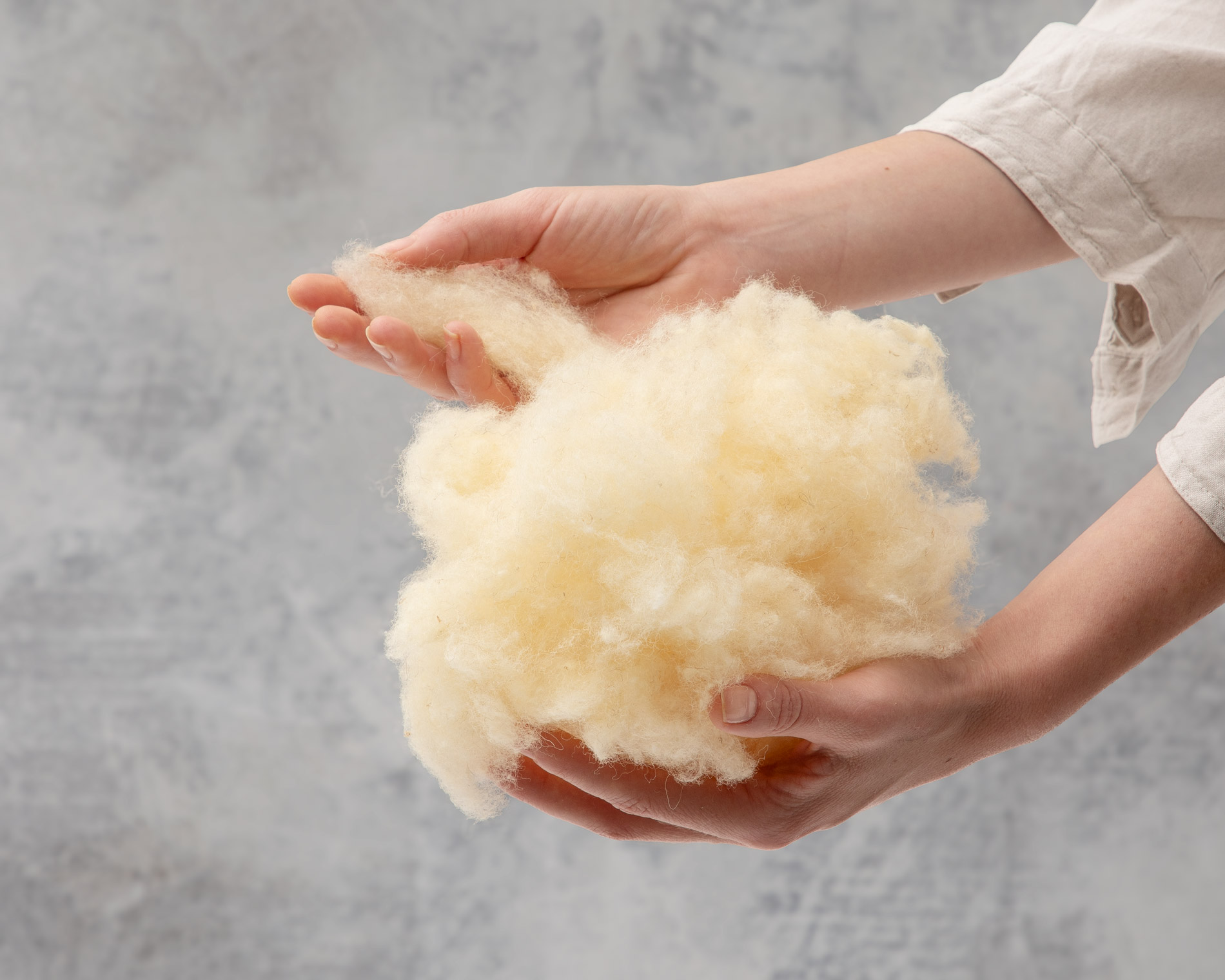 hands picking wool from a bunch